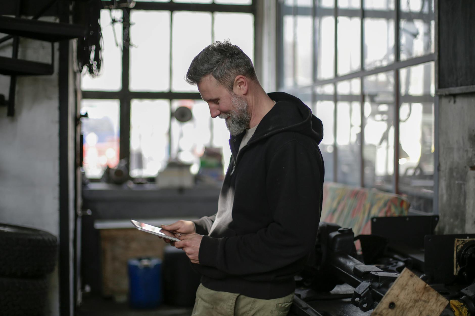 Field service technician using a mobile tablet while working on equipment